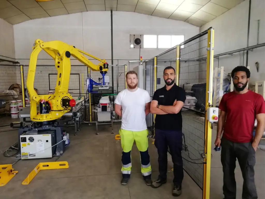 Equipo técnico junto a la instalación de paletizado automático en planta