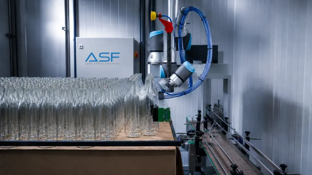 Cobot paletizando botellas en una línea de envasado